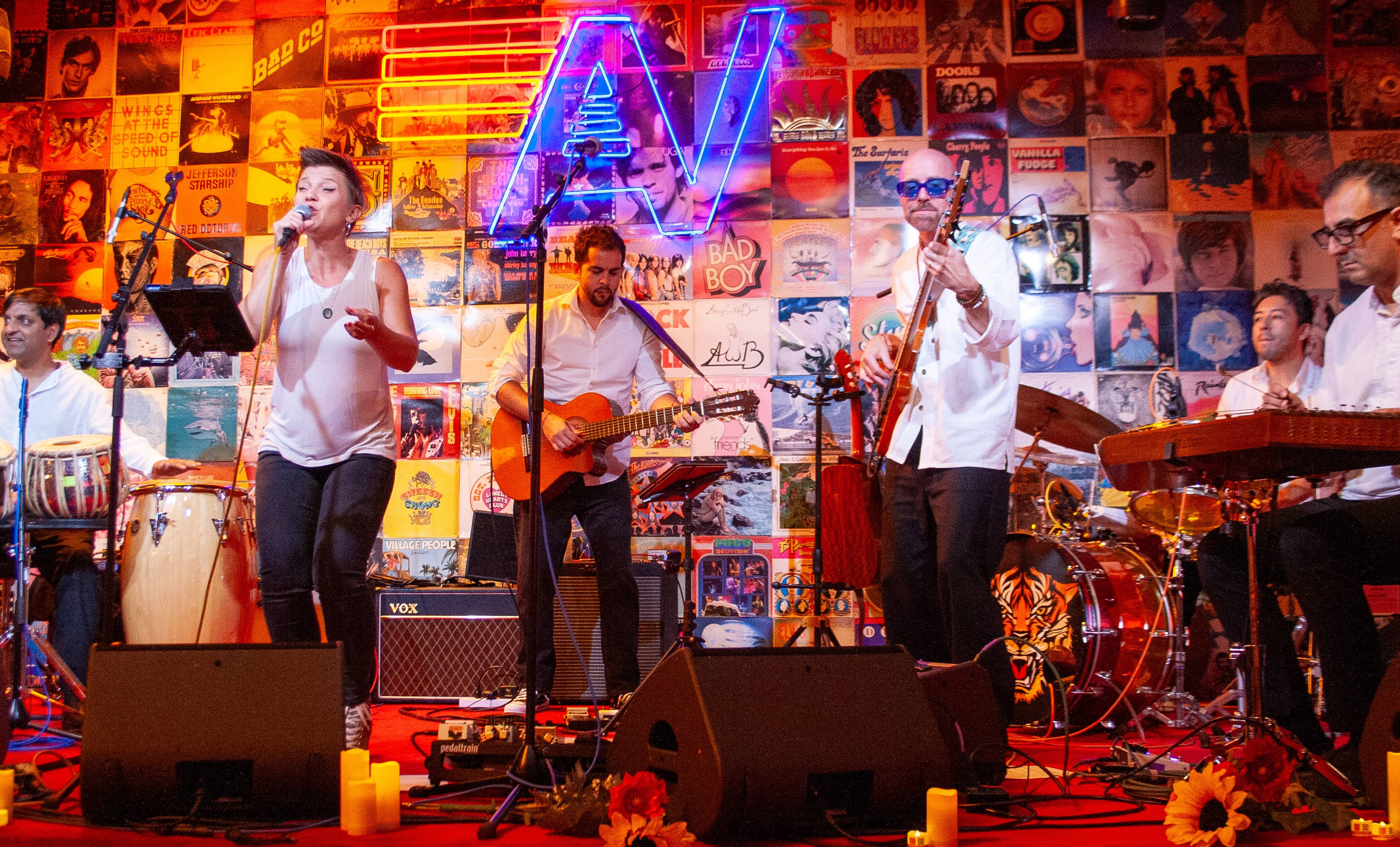 Four Fires Burn performing on a stage set with candles and sunflowers