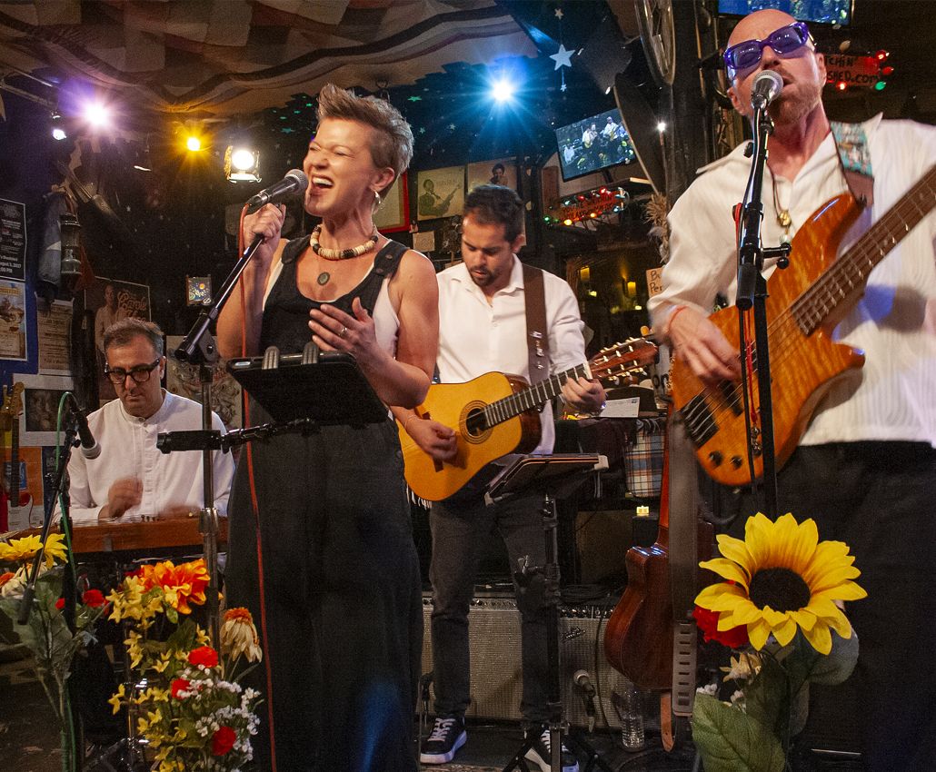 The band's singer and guitarists performing, sunflowers in the foreground